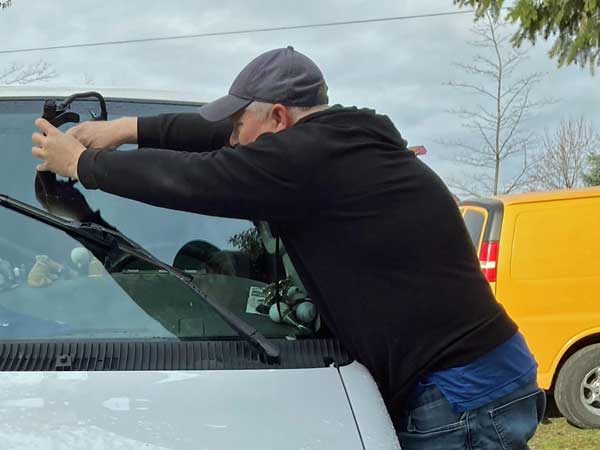 quentin fixing crack from rock on the boat's windshield